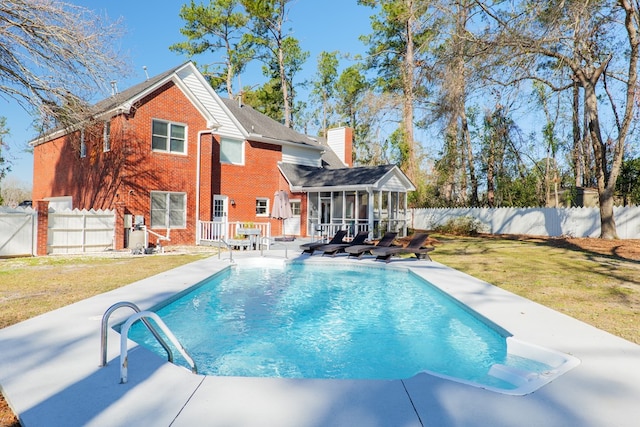 view of pool featuring a fenced in pool, a yard, a sunroom, a patio area, and a fenced backyard