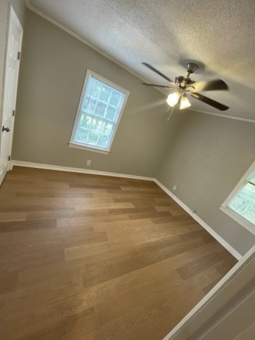 spare room featuring ceiling fan, wood-type flooring, a textured ceiling, and ornamental molding