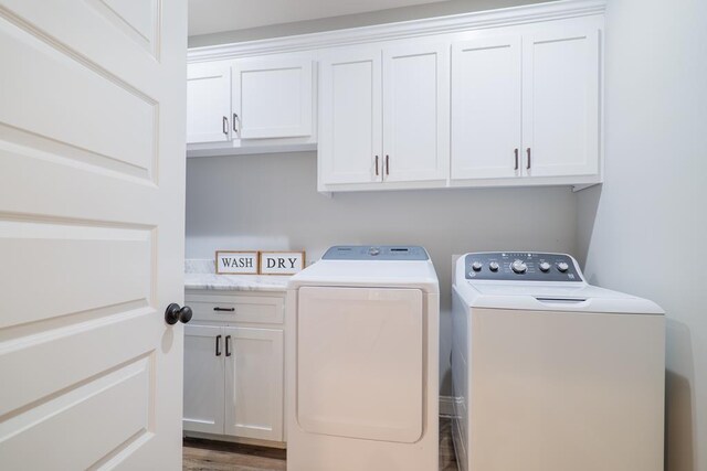 washroom featuring cabinets, independent washer and dryer, and hardwood / wood-style floors