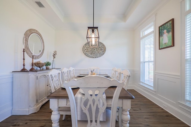 dining space with a tray ceiling, dark hardwood / wood-style flooring, and ornamental molding