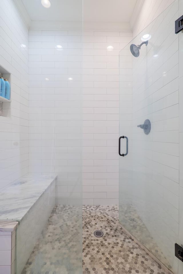 bathroom featuring walk in shower and ornamental molding