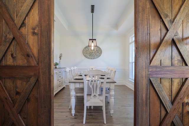 dining area featuring a barn door and dark hardwood / wood-style flooring