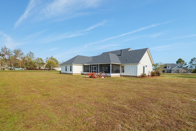 back of property featuring a lawn and a sunroom