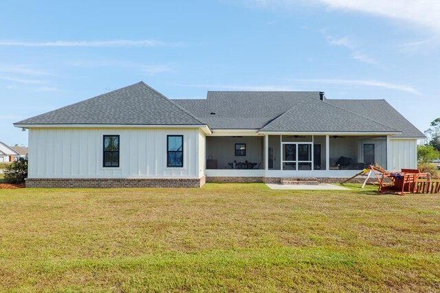 back of property with a yard and a sunroom