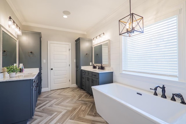 bathroom featuring parquet floors, ornamental molding, vanity, an inviting chandelier, and a bathing tub