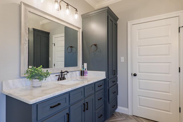 bathroom with parquet flooring, vanity, and crown molding