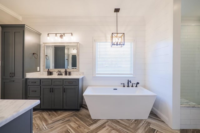 bathroom with parquet flooring, vanity, a bathtub, and ornamental molding