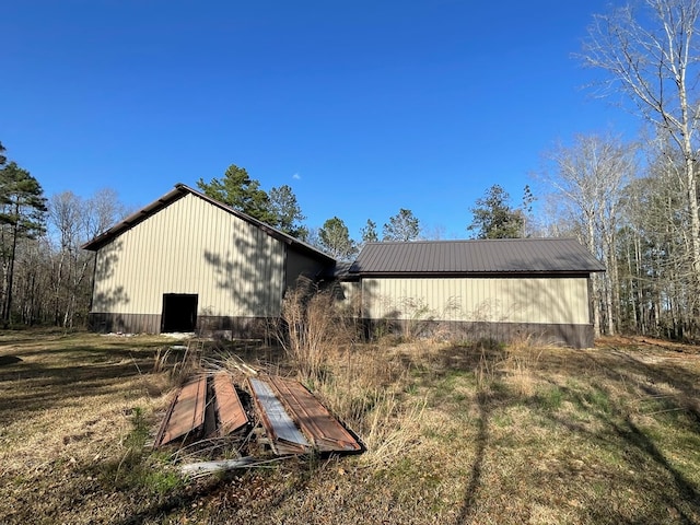 view of side of home with an outbuilding and metal roof