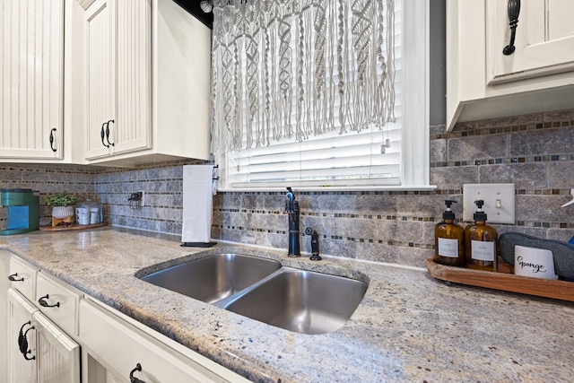 4186 Bowen Way, Valdosta, GA 31605 - kitchen featuring a sink, white cabinetry, backsplash, and light stone countertops