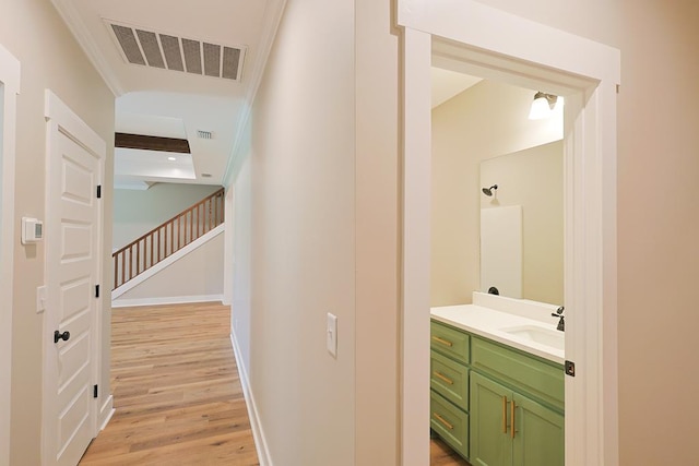 2830 Loch Laurel Rd, Valdosta, GA 31601 - hall featuring a sink, light wood-style flooring, baseboards, crown molding, and stairway