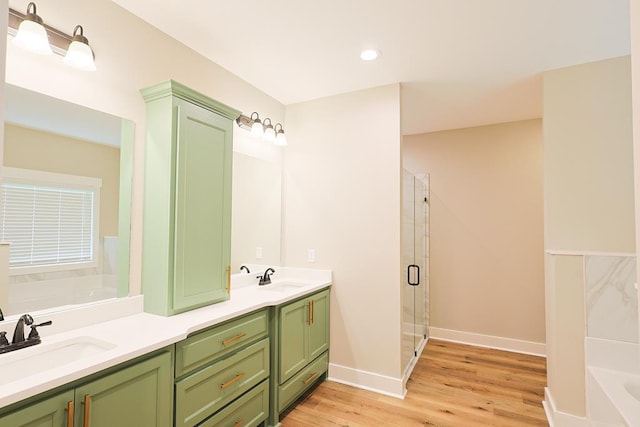 2830 Loch Laurel Rd, Valdosta, GA 31601 - full bath with a garden tub, double vanity, wood finished floors, a shower stall, and baseboards