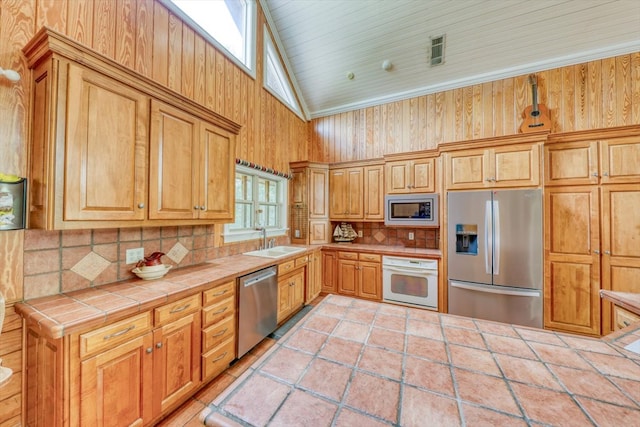 8262 Troupeville Rd, Valdosta, GA 31602 - kitchen with stainless steel appliances, tile countertops, a sink, backsplash, and high vaulted ceiling