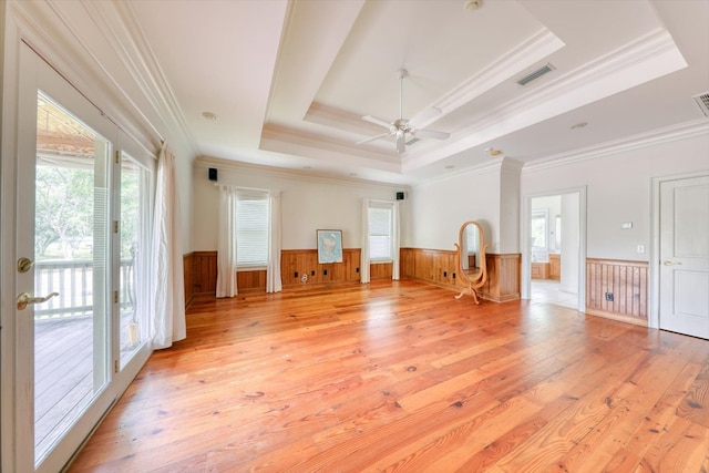 8262 Troupeville Rd, Valdosta, GA 31602 - spare room featuring a tray ceiling, a wainscoted wall, light wood finished floors, ceiling fan, and crown molding