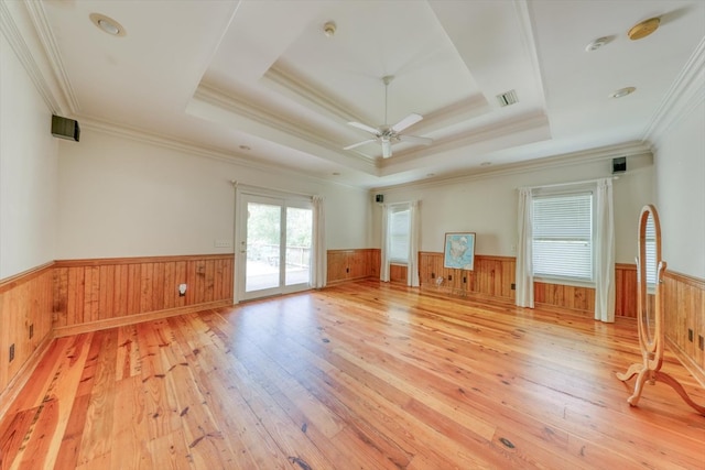 8262 Troupeville Rd, Valdosta, GA 31602 - empty room with a wainscoted wall, light wood-style floors, ceiling fan, a tray ceiling, and ornamental molding