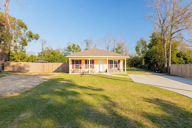 view of front facade featuring fence, driveway, and a front lawn