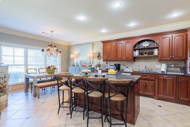 kitchen featuring open shelves, a sink, a kitchen bar, crown molding, and a kitchen island