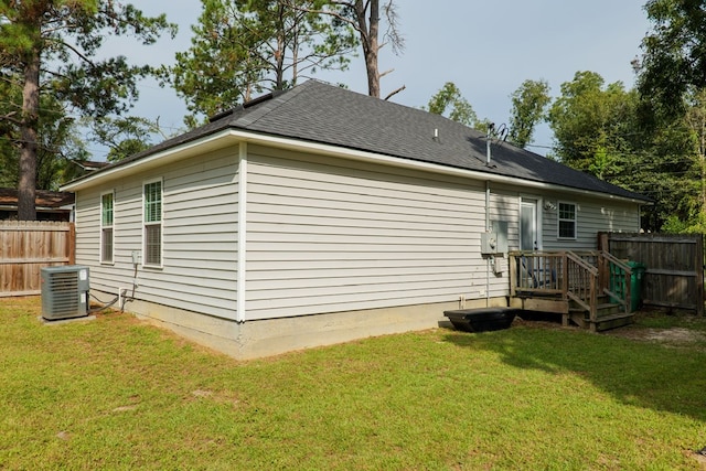 exterior space with central air condition unit and a yard