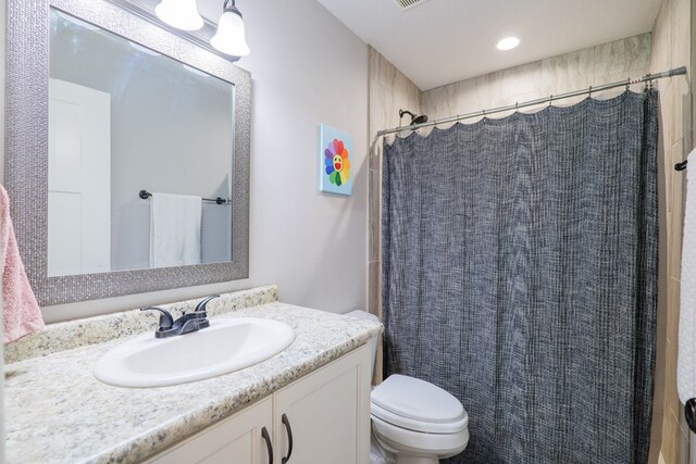 bathroom featuring a shower with curtain, vanity, and toilet