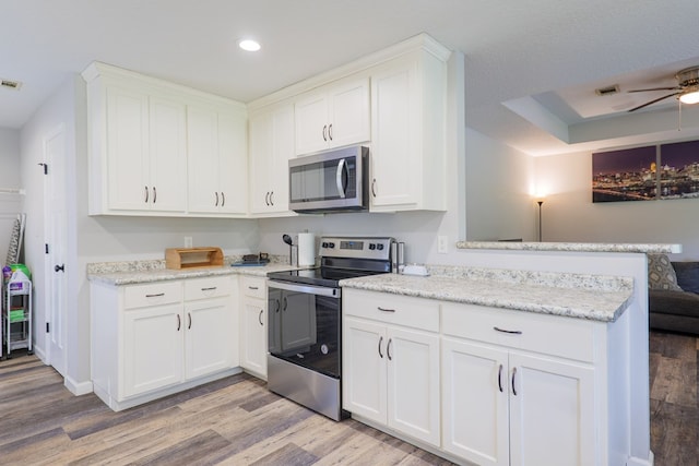 kitchen featuring white cabinetry, stainless steel appliances, and light wood-type flooring