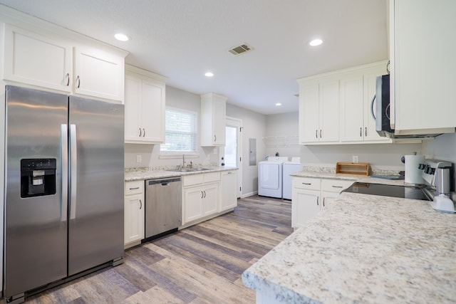 kitchen featuring appliances with stainless steel finishes, sink, wood-type flooring, separate washer and dryer, and white cabinets