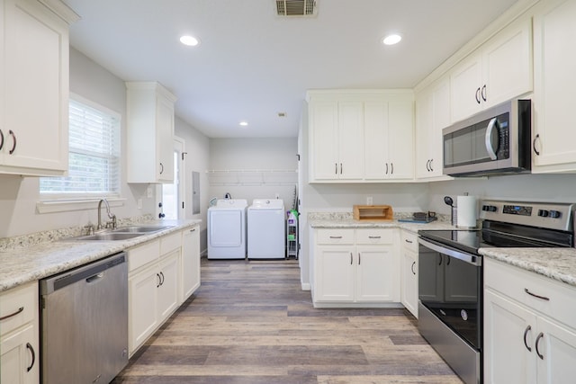 kitchen featuring white cabinetry, sink, stainless steel appliances, separate washer and dryer, and light hardwood / wood-style flooring