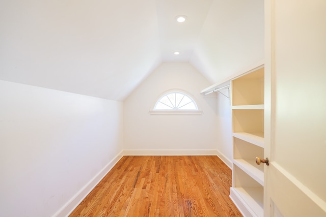 spacious closet with light wood-type flooring and vaulted ceiling