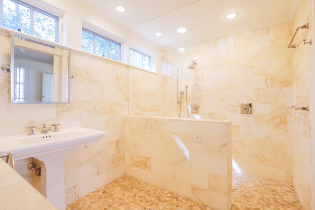 bathroom featuring tile walls, backsplash, ornamental molding, a sink, and a walk in shower