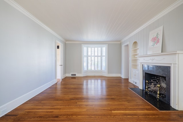 unfurnished living room with baseboards, visible vents, built in features, wood finished floors, and a high end fireplace