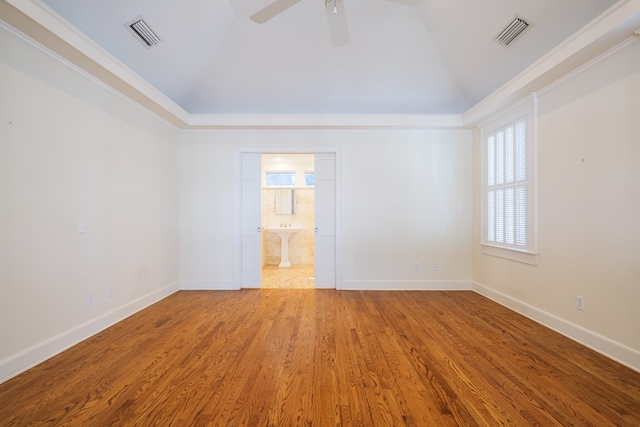 empty room featuring baseboards, visible vents, and wood finished floors