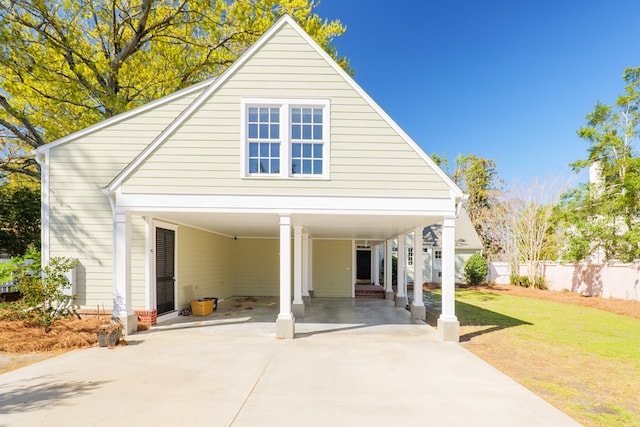 view of front of house with a carport, fence, a front lawn, and concrete driveway