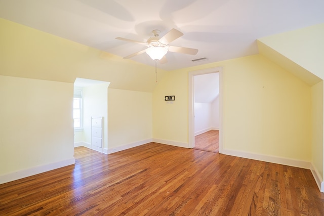 bonus room featuring visible vents, vaulted ceiling, baseboards, and wood finished floors