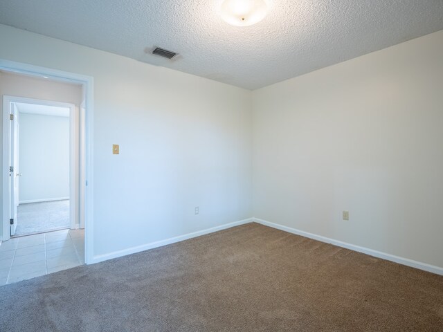 5210 N Northridge Rd, Valdosta, GA 31605 - carpeted spare room with baseboards, a textured ceiling, visible vents, and tile patterned flooring