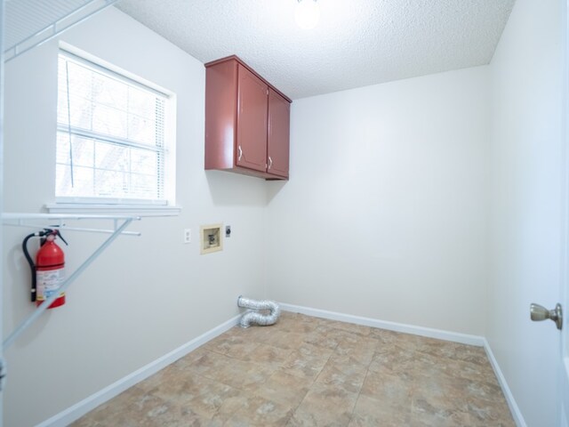 5210 N Northridge Rd, Valdosta, GA 31605 - clothes washing area with a textured ceiling, hookup for a washing machine, baseboards, electric dryer hookup, and cabinet space