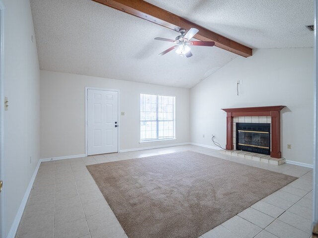 5210 N Northridge Rd, Valdosta, GA 31605 - unfurnished living room featuring lofted ceiling with beams, a textured ceiling, tile patterned floors, a ceiling fan, and a tile fireplace