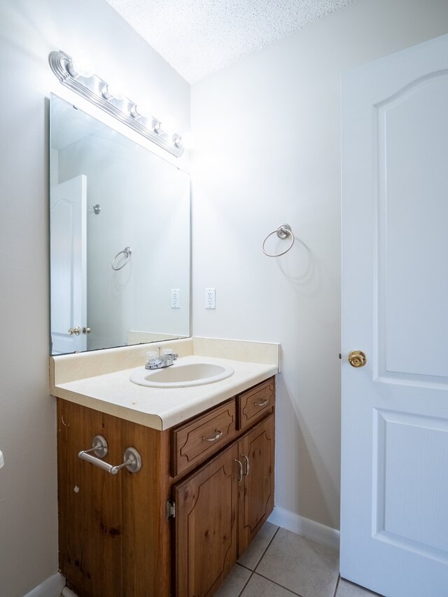 5210 N Northridge Rd, Valdosta, GA 31605 - bathroom with tile patterned flooring, vanity, baseboards, and a textured ceiling