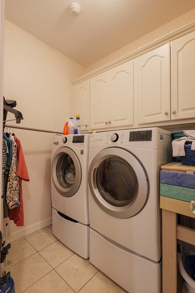 4311 Mossy Creek Rd, Valdosta, GA 31602 - washroom with cabinet space, washing machine and clothes dryer, light tile patterned floors, and baseboards