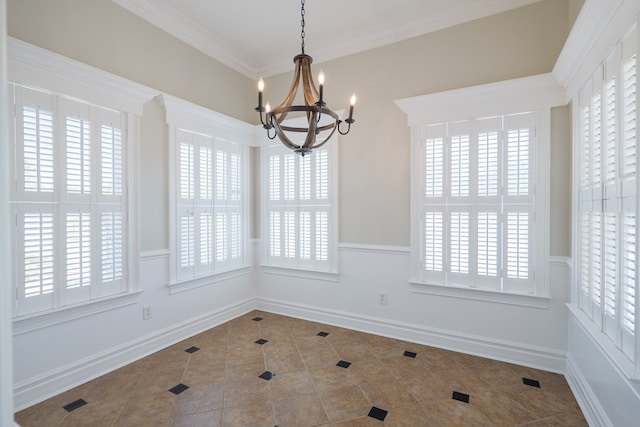 unfurnished dining area featuring ornamental molding, tile patterned flooring, baseboards, and a notable chandelier