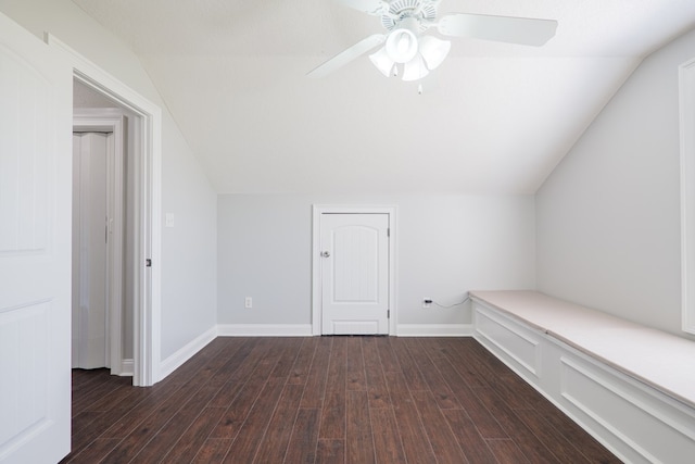 additional living space with baseboards, vaulted ceiling, dark wood-style floors, and a ceiling fan