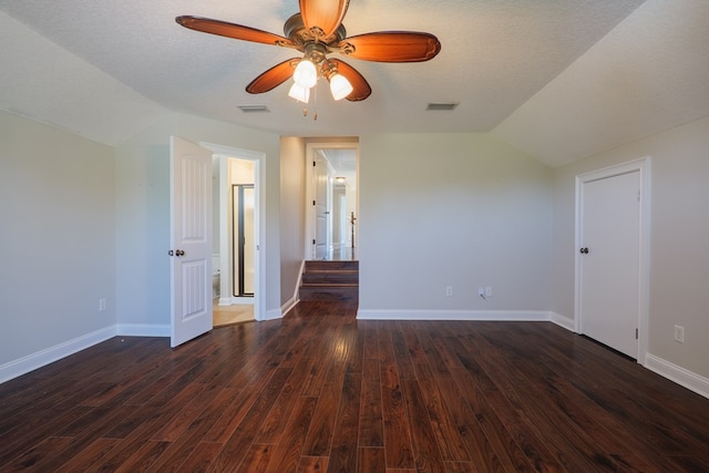 interior space featuring lofted ceiling, visible vents, ceiling fan, and dark wood-style flooring