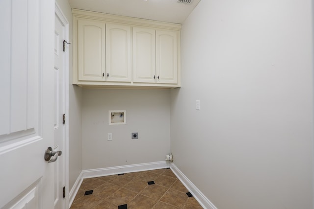 washroom with dark tile patterned floors, baseboards, electric dryer hookup, cabinet space, and washer hookup