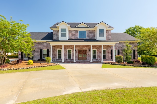 view of front facade with brick siding and a porch