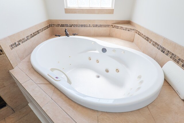 bathroom with a jetted tub and tile patterned flooring