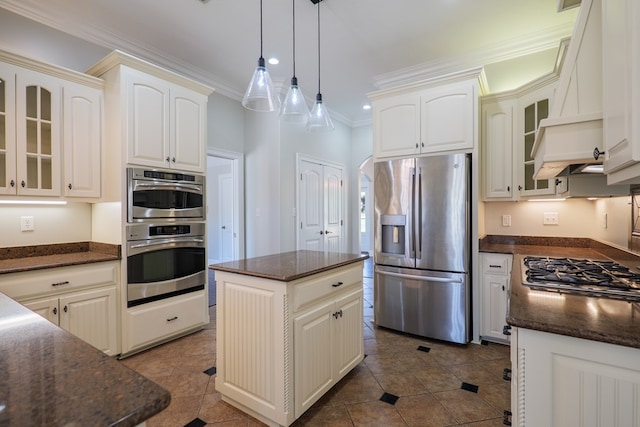 kitchen with crown molding, dark stone countertops, hanging light fixtures, glass insert cabinets, and stainless steel appliances