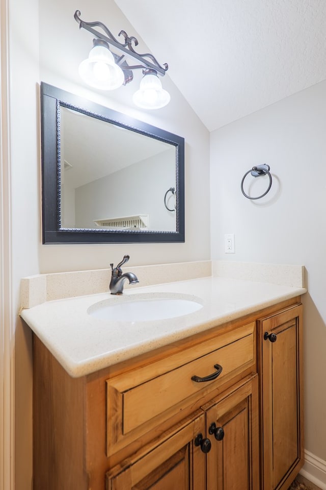 bathroom with lofted ceiling and vanity