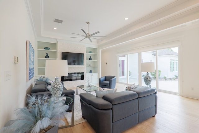 3870 Timber Ridge Rd, Valdosta, GA 31601 - living room with ornamental molding, built in features, a ceiling fan, light wood-style floors, and a large fireplace