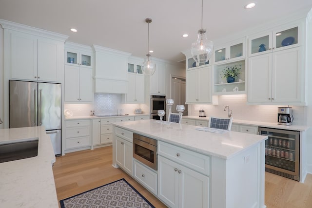 3870 Timber Ridge Rd, Valdosta, GA 31601 - kitchen featuring appliances with stainless steel finishes, wine cooler, decorative backsplash, light wood-type flooring, and recessed lighting
