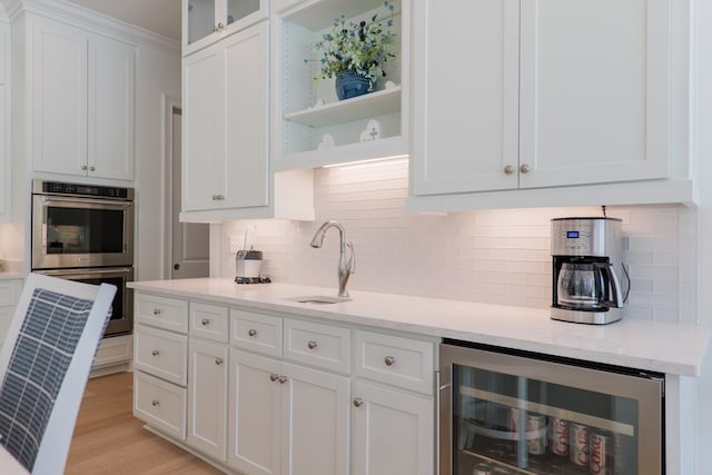 3870 Timber Ridge Rd, Valdosta, GA 31601 - kitchen with beverage cooler, stainless steel double oven, white cabinets, and open shelves