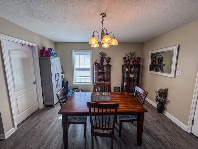 dining area with baseboards, a chandelier, dark wood finished floors, and a textured ceiling