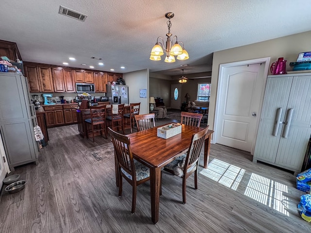 dining space with recessed lighting, visible vents, an inviting chandelier, dark wood-type flooring, and a textured ceiling