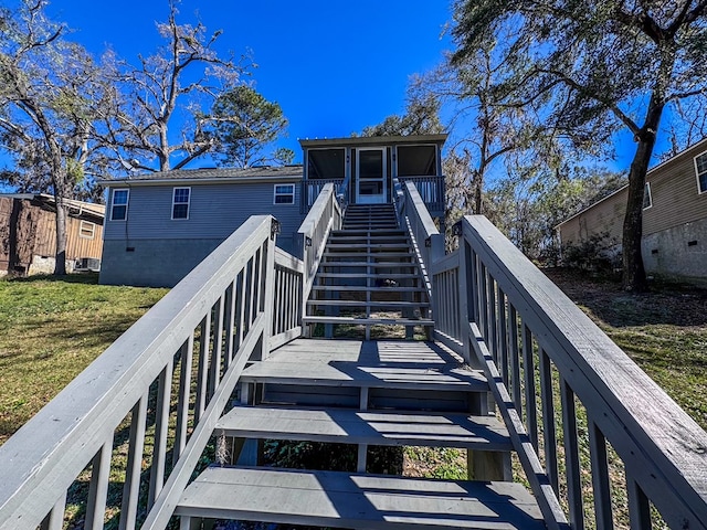 rear view of property featuring a deck, stairway, and a sunroom